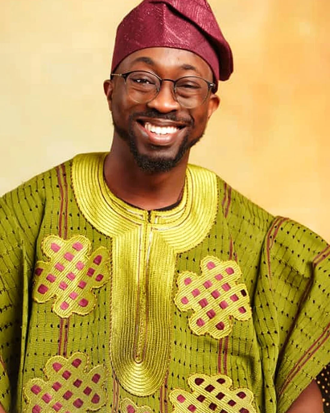 Oluseyi Oladepo, smiling, in a green agbada and burgundy fila