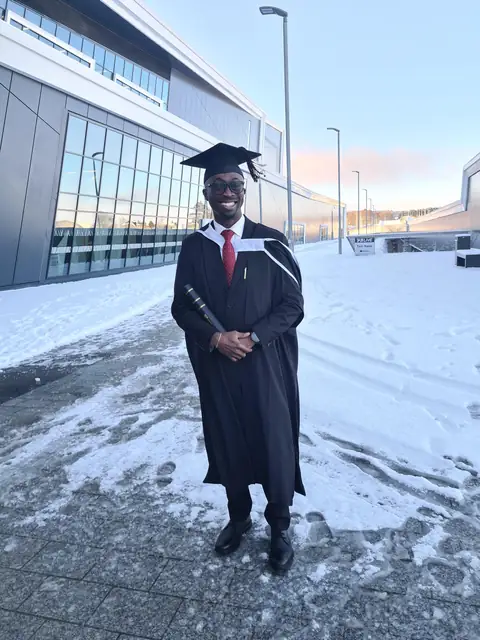 Oluseyi in cap and gown on graduation day