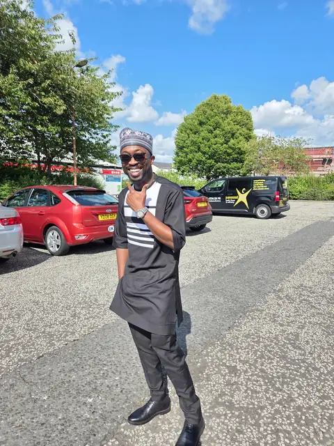 Oluseyi in a patterned agbada and cap