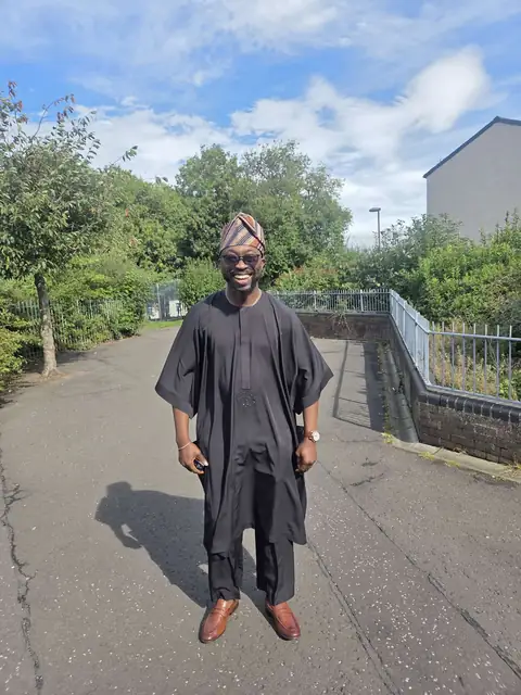 Oluseyi in his graduation gown outdoors