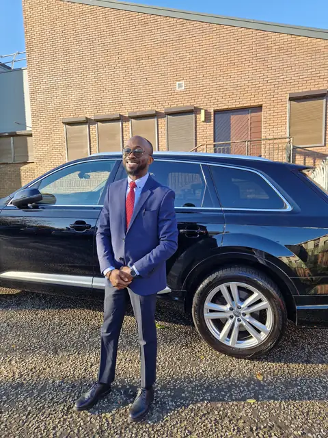 Oluseyi in a navy suit and red tie