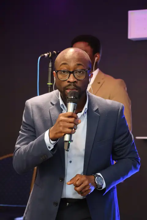 Oluseyi speaking to an audience, microphone in hand