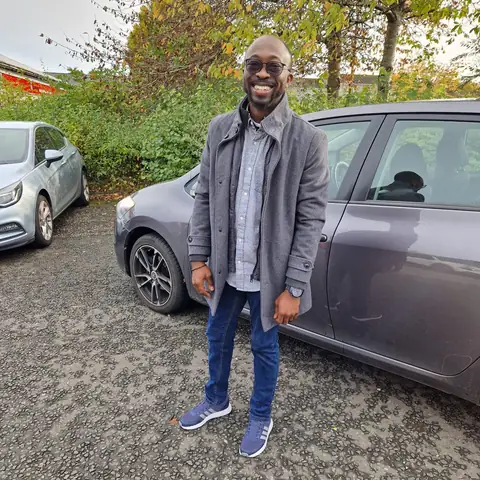 Oluseyi in a grey jacket and sunglasses